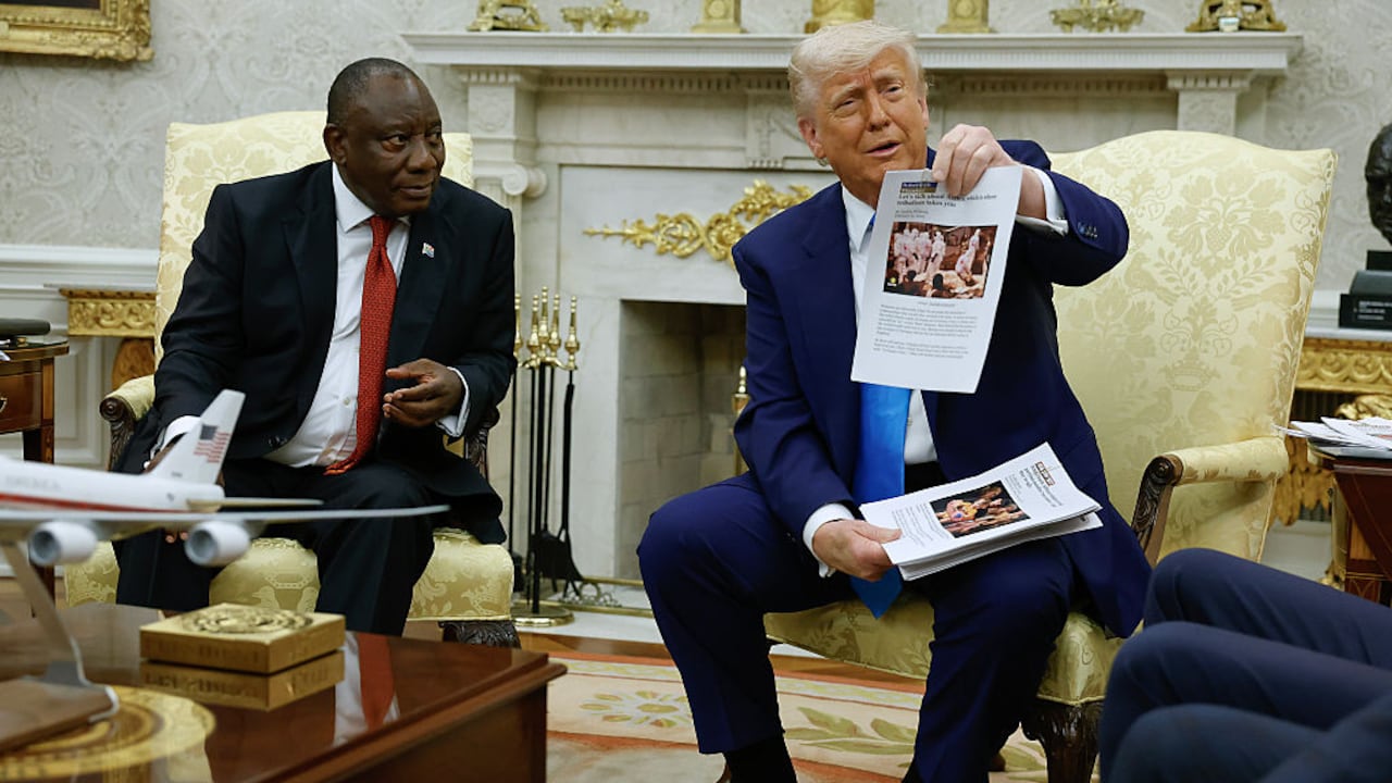 WASHINGTON, DC - MAY 21: U.S. President Donald Trump holds up a printed article from "American Thinker" while accusing South Africa President Cyril Ramaphosa of state-sanctioned violence against white farmers in South Africa during a press availability in the Oval Office at the White House on May 21, 2025 in Washington, DC. Relations between the two countries have been strained since Trump signed an executive order in February that claimed white South Africans are the victims of government land confiscation and race-based “genocide,” while admitting some of those Afrikaners as refugees to the United States. Trump also halted all foreign aid to South Africa and expelled the country’s Ambassador to the U.S., Ebrahim Rasool. (Photo by Chip Somodevilla/Getty Images)