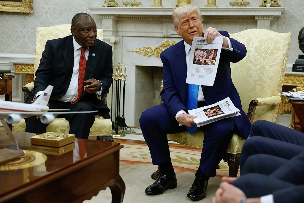 WASHINGTON, DC - MAY 21: U.S. President Donald Trump holds up a printed article from "American Thinker" while accusing South Africa President Cyril Ramaphosa of state-sanctioned violence against white farmers in South Africa during a press availability in the Oval Office at the White House on May 21, 2025 in Washington, DC. Relations between the two countries have been strained since Trump signed an executive order in February that claimed white South Africans are the victims of government land confiscation and race-based “genocide,” while admitting some of those Afrikaners as refugees to the United States. Trump also halted all foreign aid to South Africa and expelled the country’s Ambassador to the U.S., Ebrahim Rasool. (Photo by Chip Somodevilla/Getty Images)