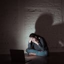 Sad and scared female Young woman with computer laptop suffering cyberbullying and harassment being online abused by stalker or gossip feeling desperate and humiliated in cyber bullying concept.