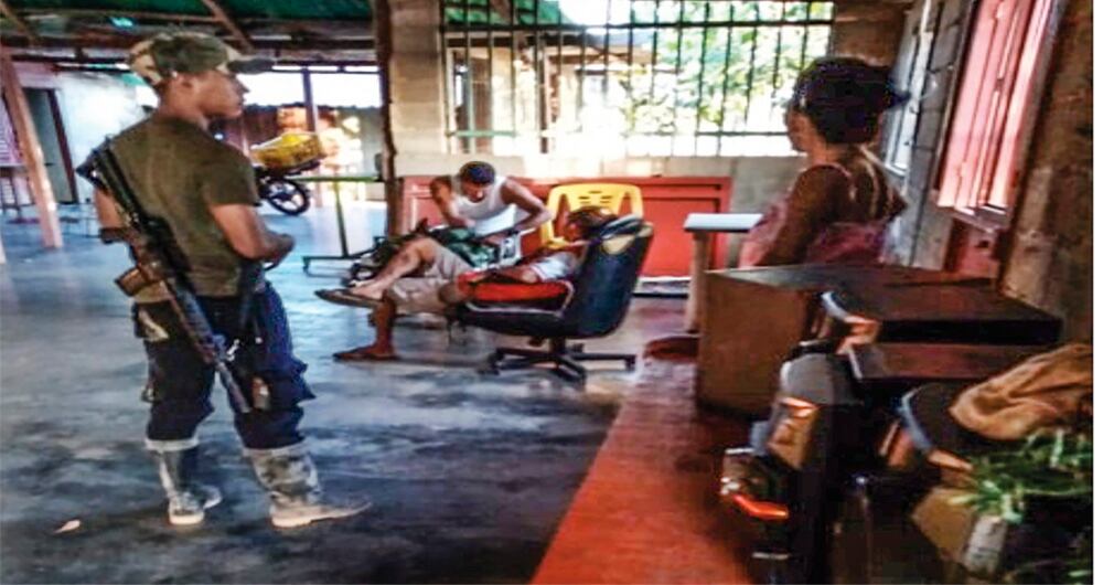 Uno de los jefes de seguridad de Romaña aparece con un fusil, en lo que sería un estadero en Venezuela. 