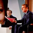 El presidente Emmanuel Macron hace un gesto frente a una pantalla que lo muestra, durante una entrevista en el Palacio del Elíseo en París.(Photo by Ludovic MARIN / AFP)