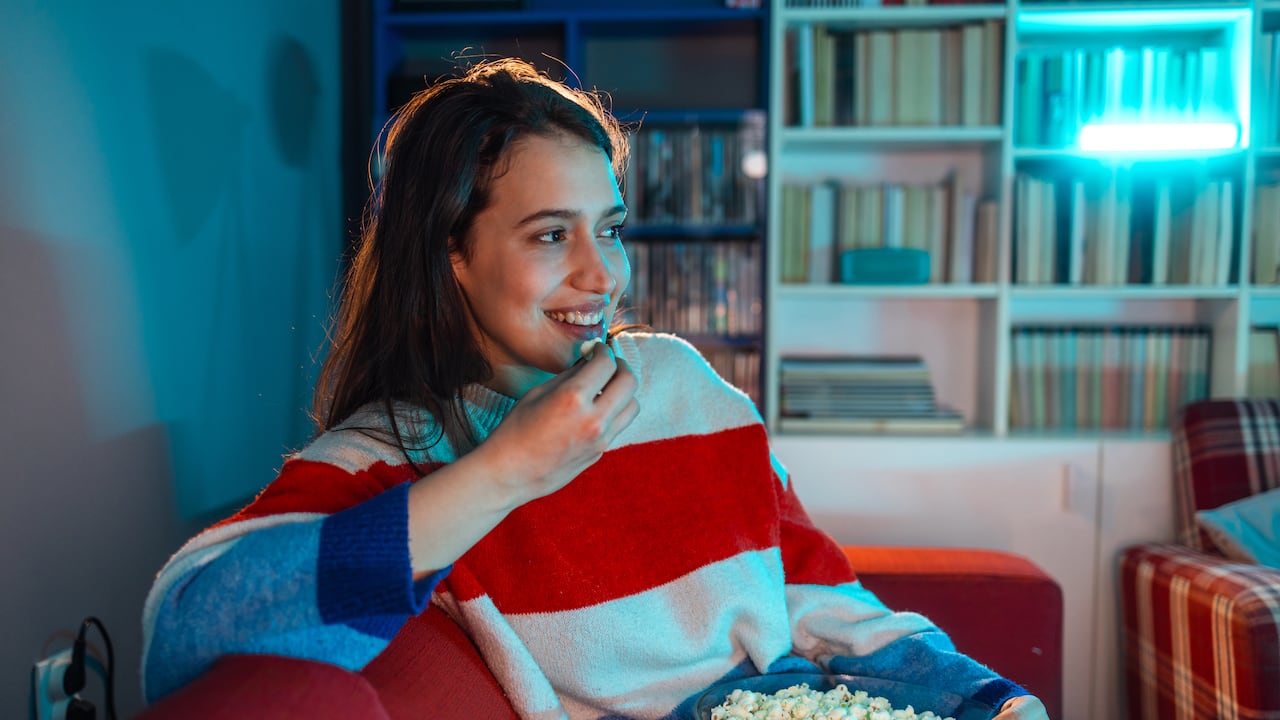 Joven disfrutando de películas y series desde la comodidad de su casa.
