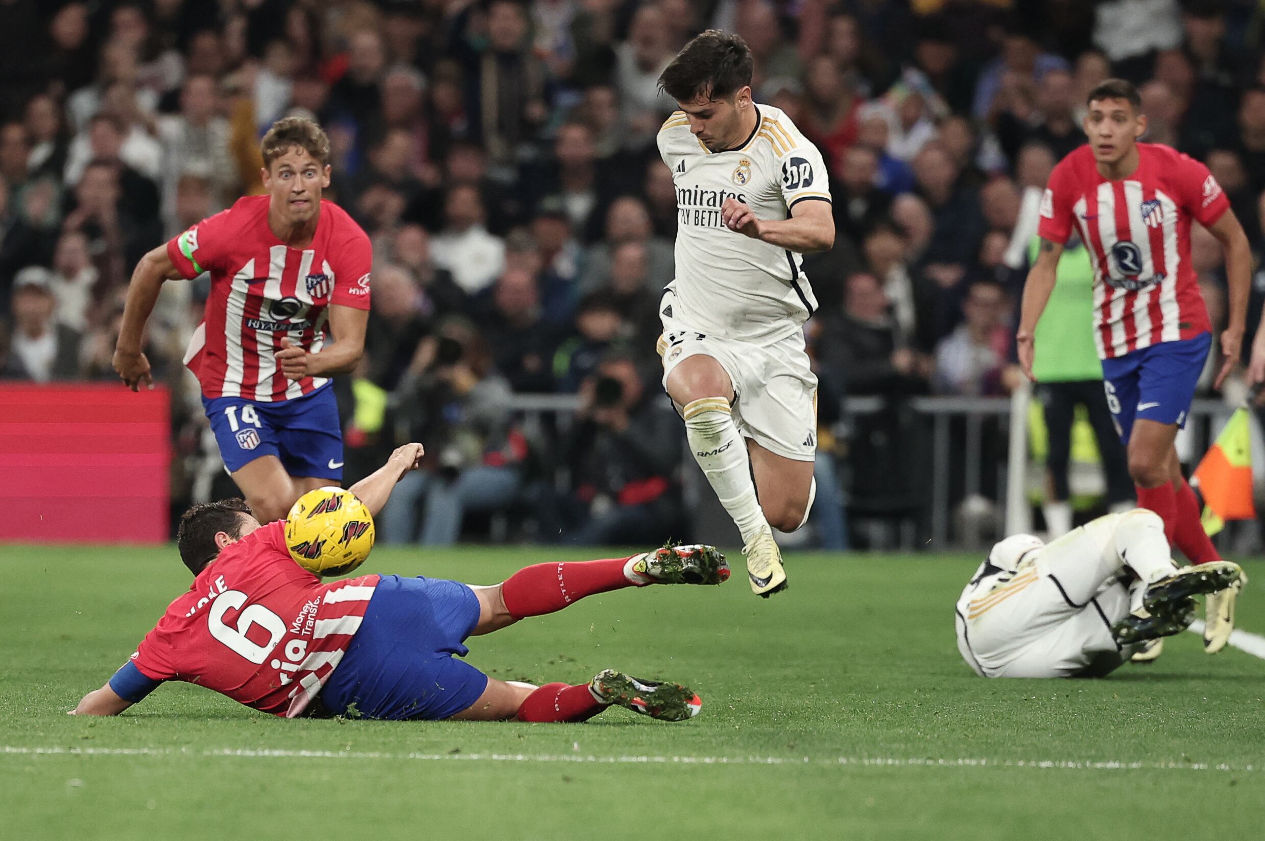 Atletico Madrid's Spanish midfielder #06 Koke fights for the ball with Real Madrid's Spanish forward #21 Brahim Diaz during the Spanish league football match between Real Madrid CF and Club Atletico de Madrid at the Santiago Bernabeu stadium in Madrid on February 4, 2024. (Photo by Thomas COEX / AFP)