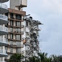 Rubble hangs from a partially collapsed building in Surfside north of Miami Beach, on June 24, 2021. - The multi-story apartment block in Florida partially collapsed early June 24, sparking a major emergency response. Surfside Mayor Charles Burkett told NBC�s Today show: �My police chief has told me that we transported two people to the hospital this morning at least and one has died. We treated ten people on the site.� (Photo by CHANDAN KHANNA / AFP)
