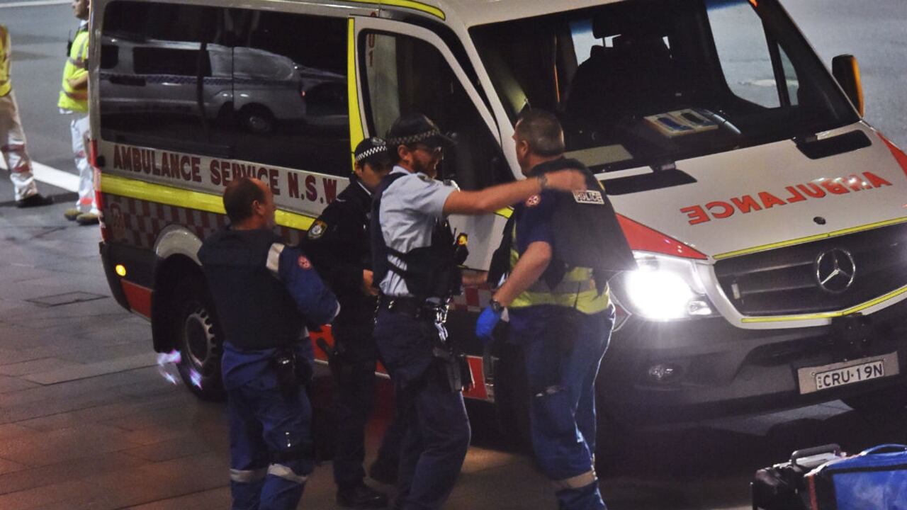 Agentes de policía colocan chalecos antibalas a personal sanitario, durante la operación policial llevada a cabo en una cafetería tomada en Sídney.