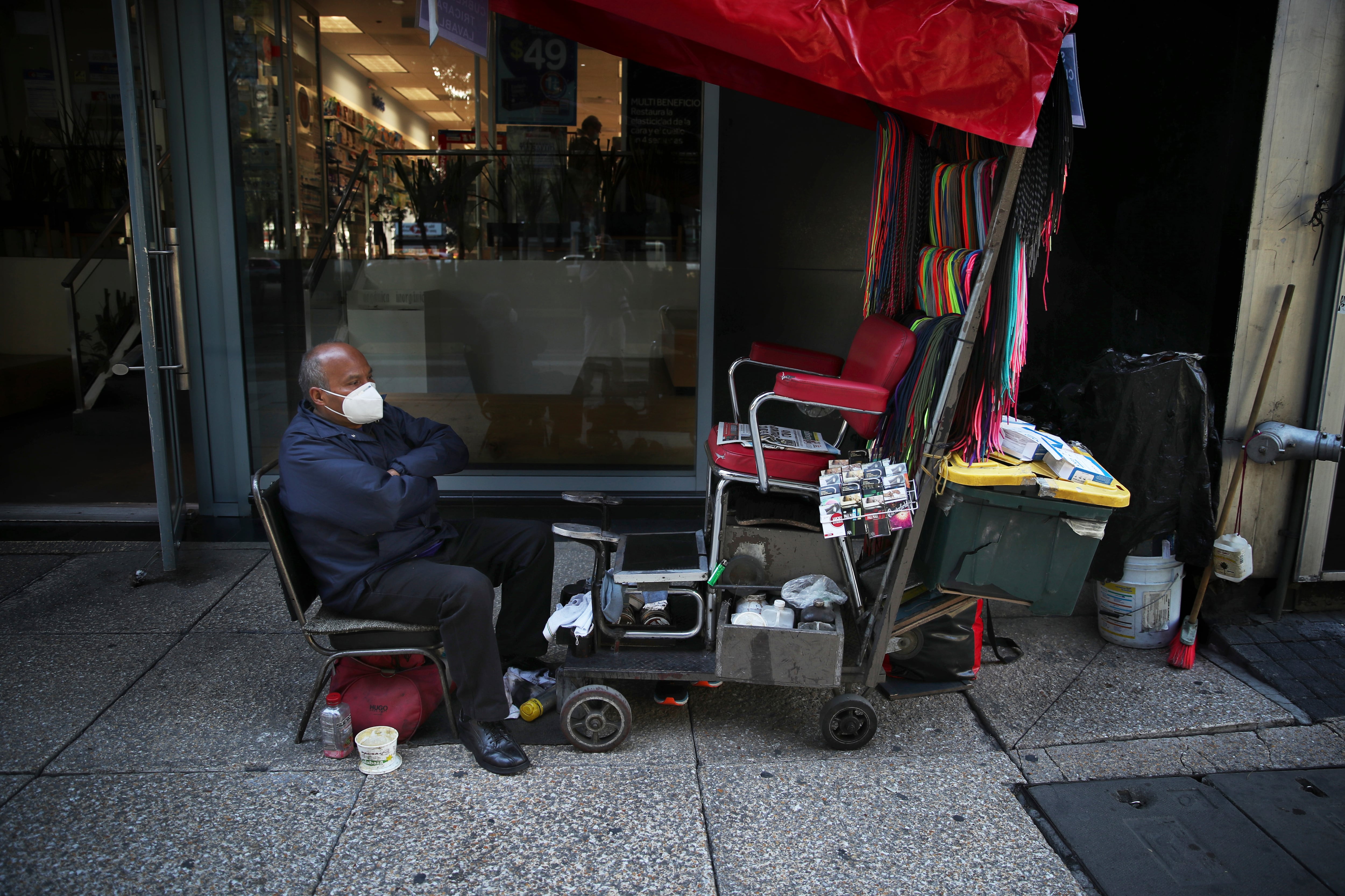 El limpiabotas José García espera a los clientes durante la pandemia de COVID-19 en el Paseo de la Reforma en la Ciudad de México. (AP Photo / Marco Ugarte)