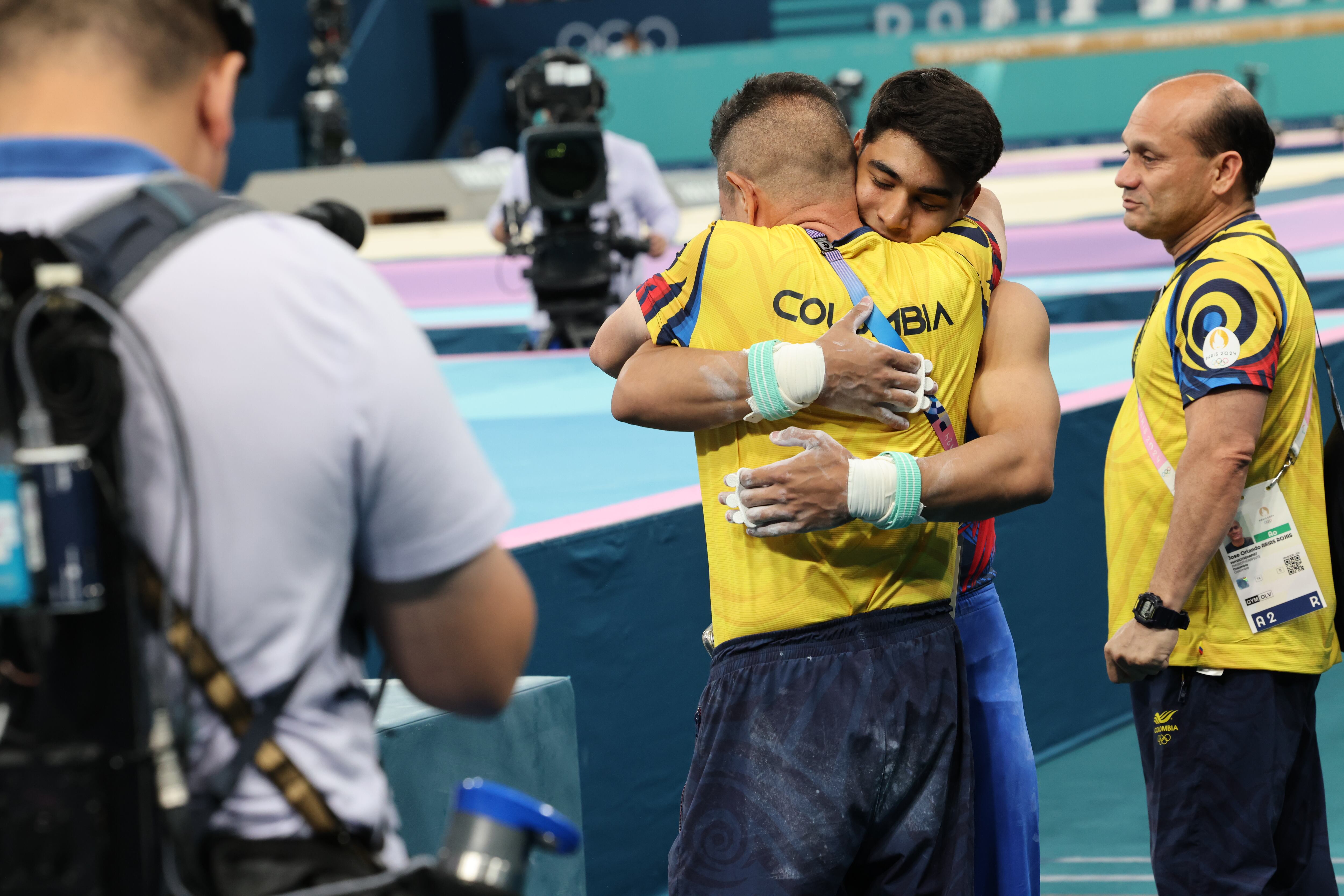 Ángel y el profesor Jairo luego de finalizar la rutina en la final de la barra fija de París 2024.