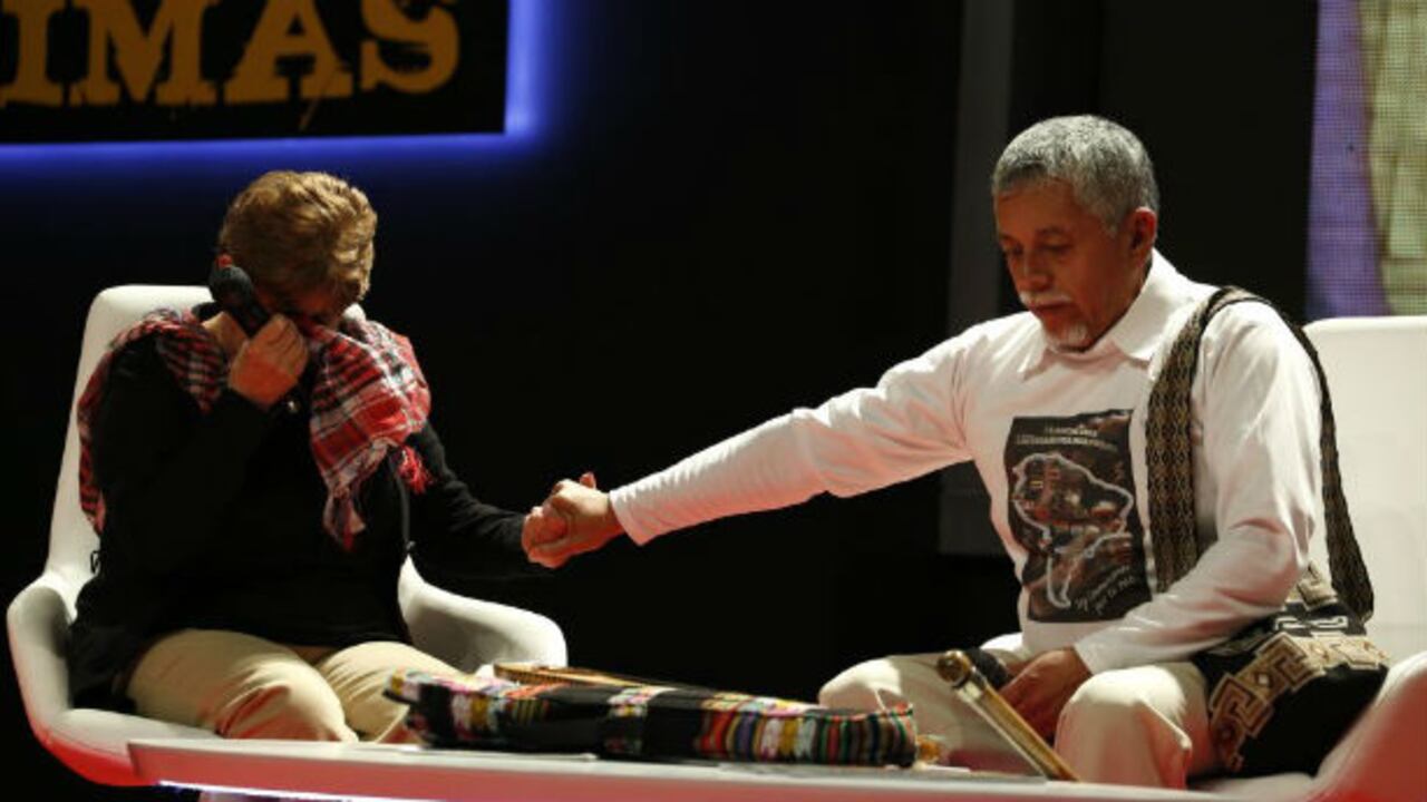 El profesor Gustavo Moncayo le sostiene la mano a Teresita Gaviria, líder de las Madres de la Candelaria, mientras ella cuenta la historia de su hijo desaparecido.