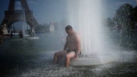 Una persona se refresca en una fuente en el Trocadero, cerca de la Torre Eiffel, durante una ola de calor, en París, el 24 de junio de 2026. (AP Foto/Christophe Ena)