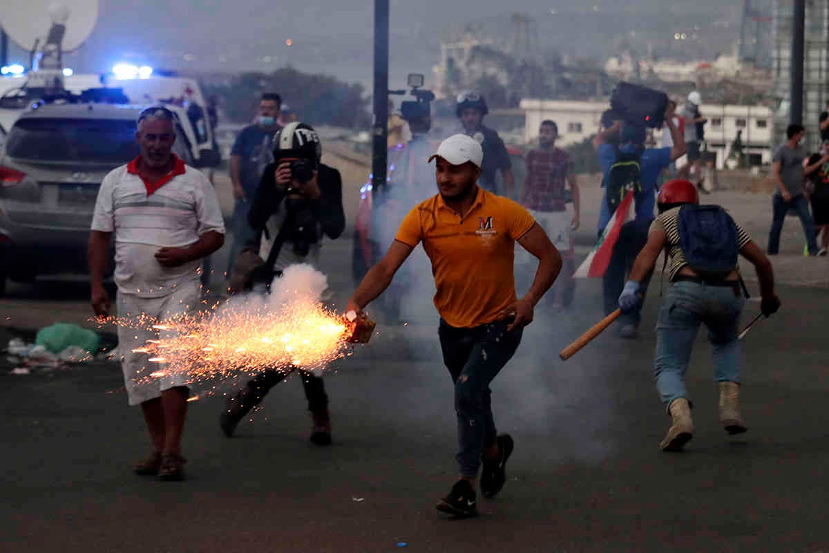 Los manifestantes antigubernamentales utilizan fuegos artificiales contra la policía antidisturbios. AP Photo/Hassan Ammar.