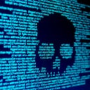 Código de computadora en una pantalla con una calavera que representa un ataque de malware/virus informático.