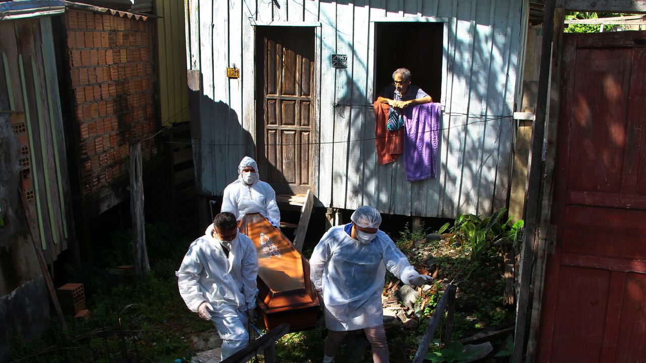 Un familiar observa cómo los trabajadores del servicio funerario público retiran el cuerpo de Amelia Dias Nascimento, de 94 años, quien murió por complicaciones relacionadas con el COVID-19 en su casa, en Manaus, estado de Amazonas. (Foto AP / Edmar Barros, archivo)