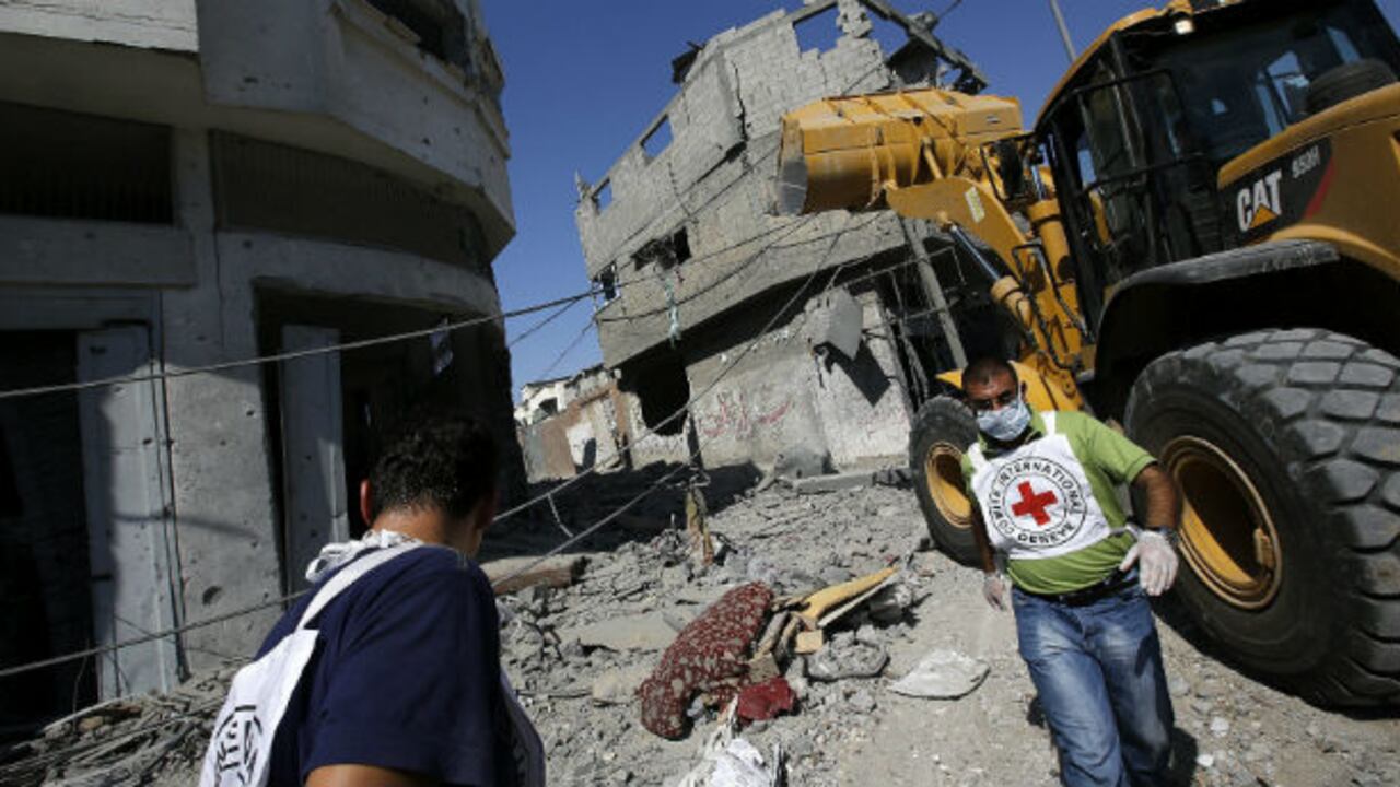 Unos trabajadores de la Cruz Roja caminan entre decenas de edificios destruídos tras los ataques aéreos israelíes sobre el barrio de Al Shejaeiya en la ciudad de Gaza. (EFE)