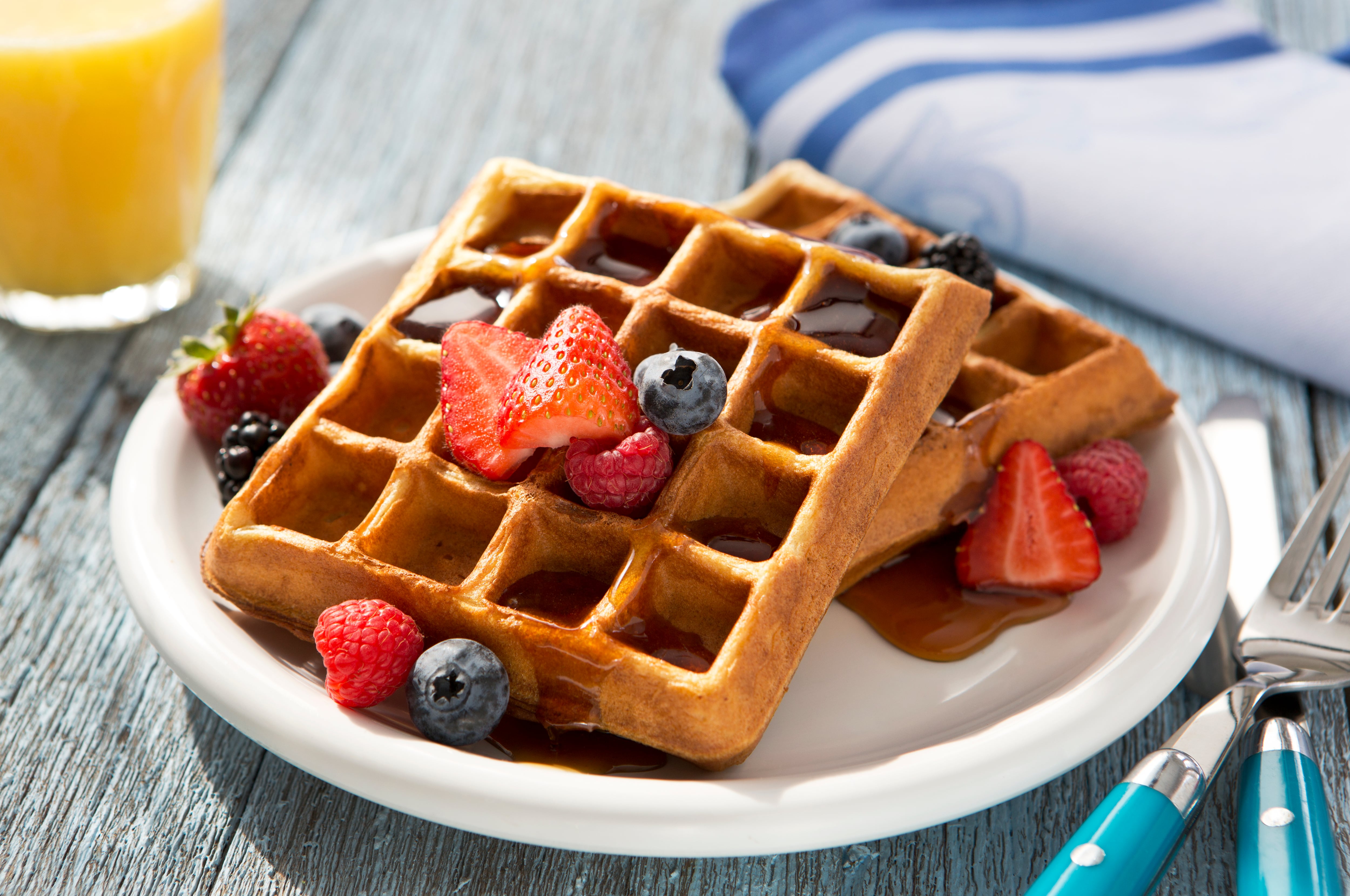 Waffles saludables para el desayuno con mezcla de toppings nutritivos como fresas y arándanos.