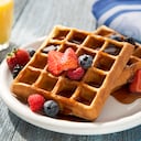 Waffles saludables para el desayuno con mezcla de toppings nutritivos como fresas y arándanos.