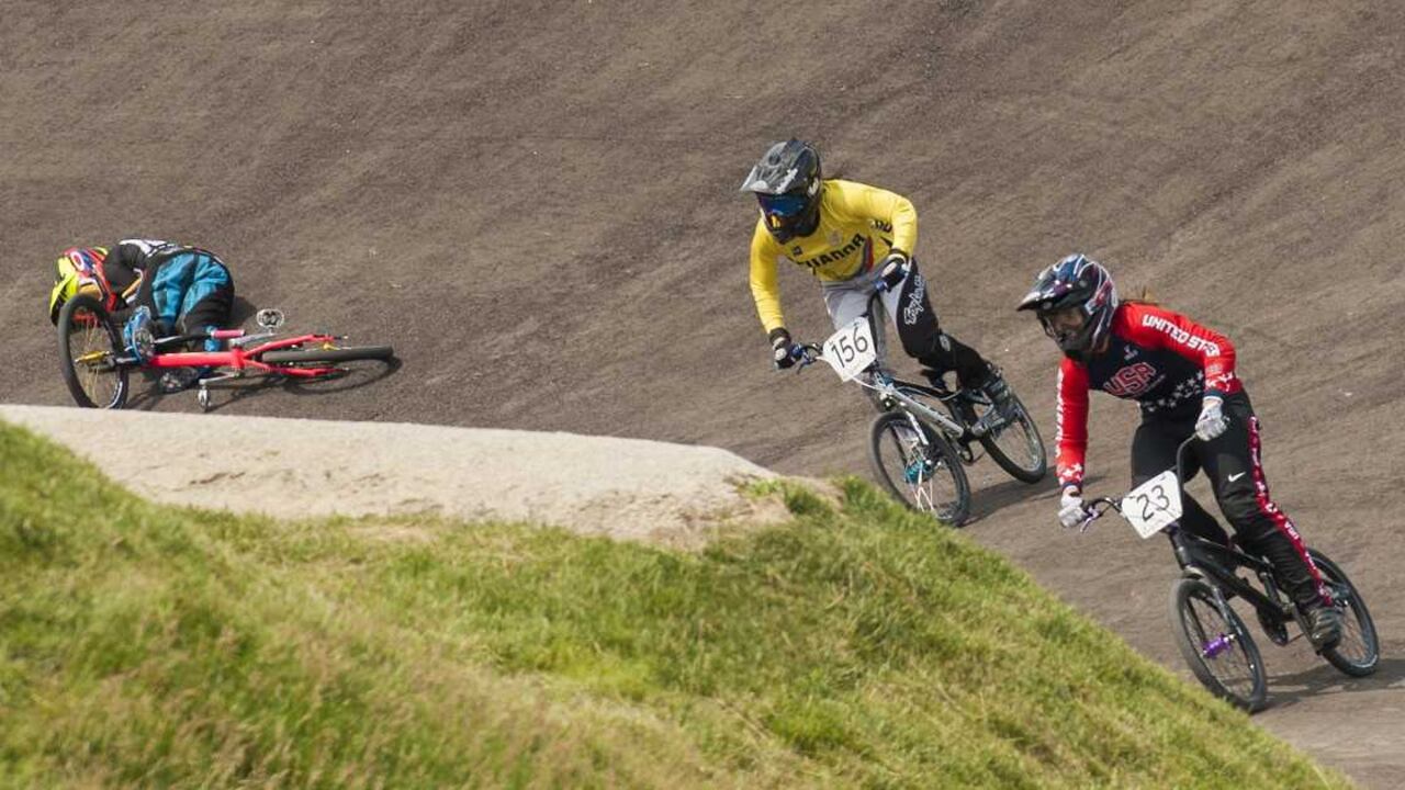 Mariana Pajón Londoño de Colombia (izq.) yace en el suelo tras caerse de la bicicleta en la serie final de carreras BMX femenina durante los Juegos Panamericanos de Toronto 2015, este sábado 11 de julio, 2015. Felicia Stancil (d) ganó la medalla de oro y Domenica Azuero Gonzalez (c) la de plata