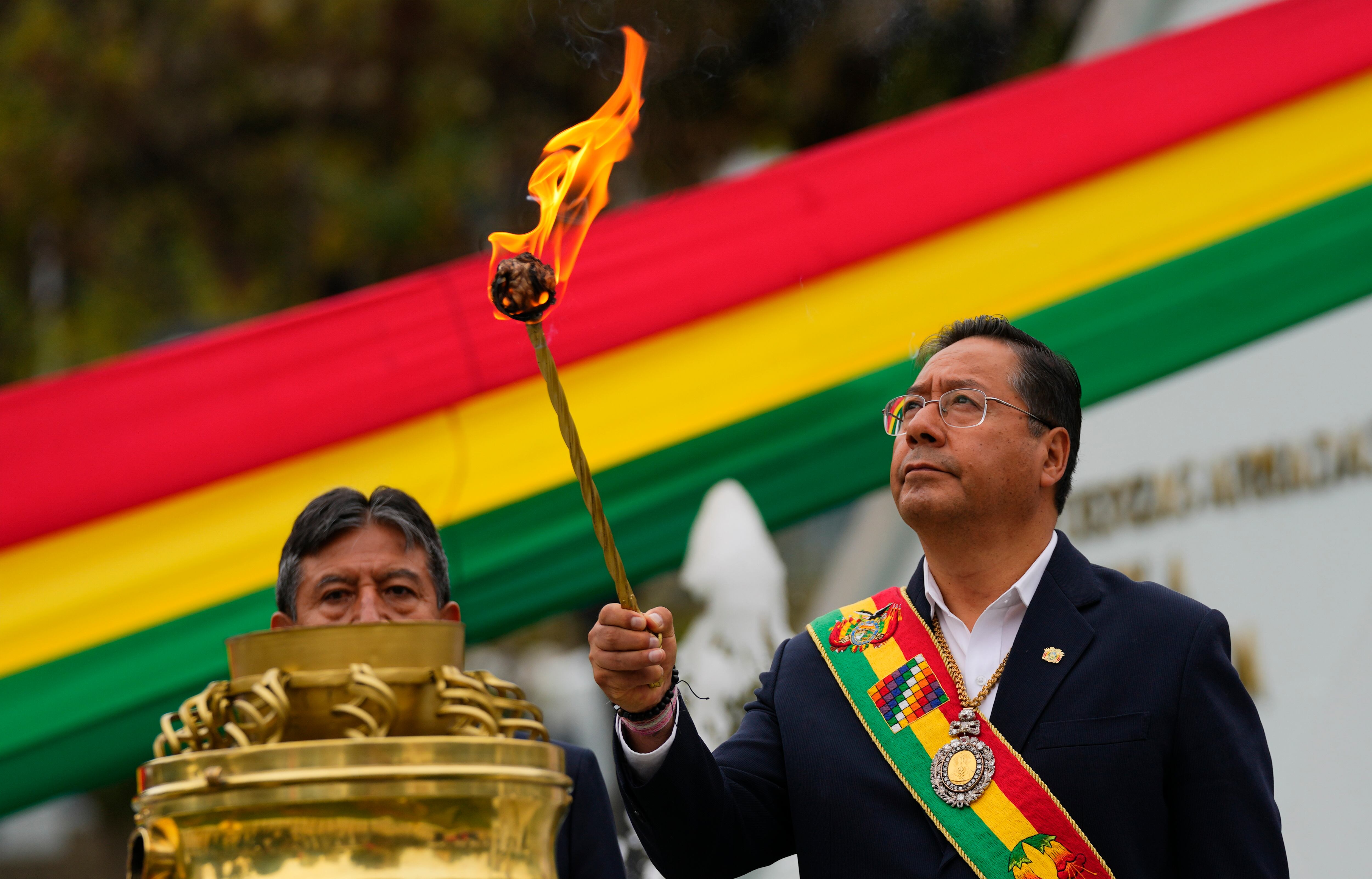 El presidente boliviano Luis Arce sostiene una antorcha durante las celebraciones del Día del Mar en La Paz, Bolivia, el 22 de marzo de 2024. Vehículos blindados chocaron contra las puertas del palacio de gobierno de Bolivia el miércoles 26 de junio de 2024, mientras un alto funcionario del gobierno advertía sobre un golpe intentar.