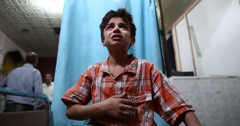 Un niño sirio herido llora mientras espera tratamiento en la clínica, después de un ataque en Damasco. 18 de agosto del 2016. Foto: AFP.