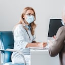 Mujer médico use mascarilla de protección hablando con el paciente en la oficina de la clínica.