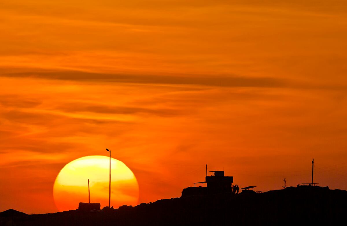 El sol se oculta tras un puesto de observación turco con vista a la ciudad siria de Kobani. La ciudad, también conocida como Ayn Arab, ha estado bajo el ataque de extremistas del Estado Islámico desde mediados de septiembre. (AP)