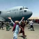 Cientos de personas corren al lado de un avión C-17 de la Fuerza Aérea de EEUU mientras avanza por la pista del aeropuerto internacional de Kabul, Afganistán, el lunes 16 de agosto de 2021. (UGC verificado, vía AP)