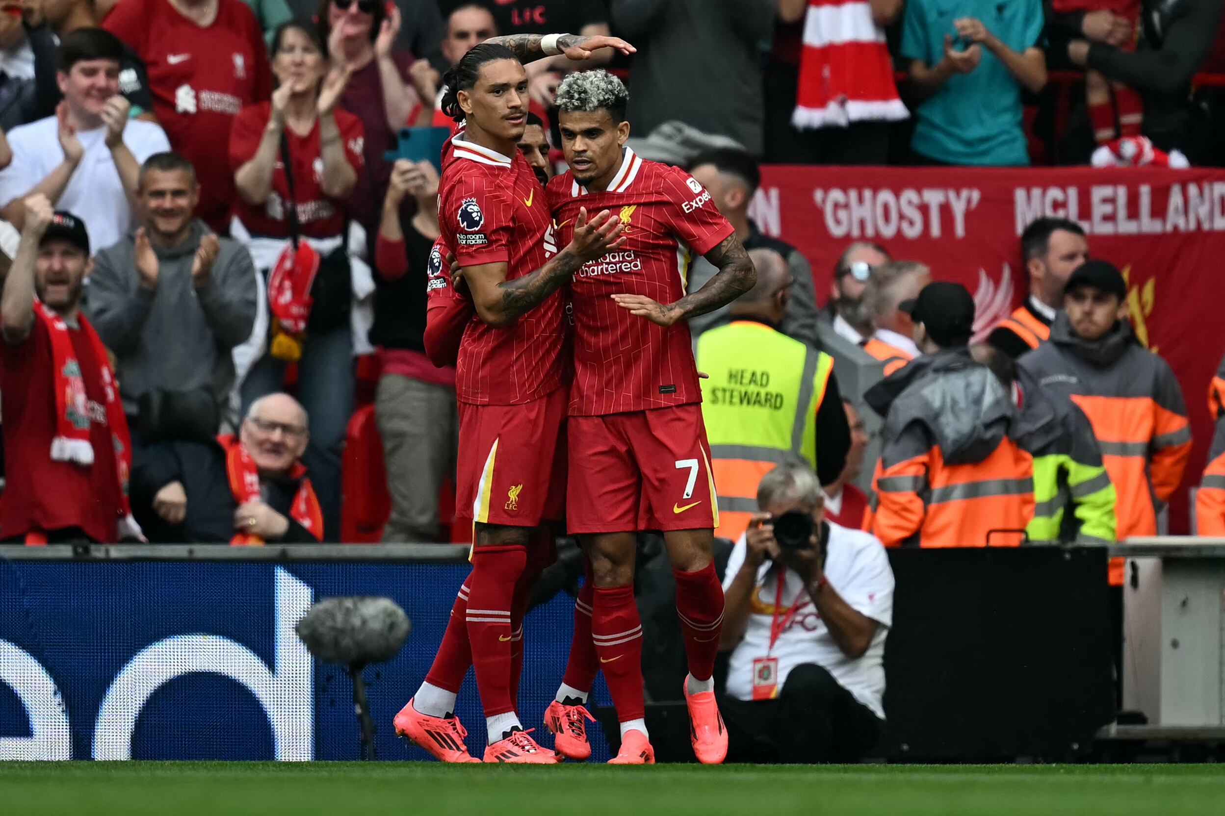 Liverpool's Colombian midfielder #07 Luis Diaz (R) celebrates after scoring his team's first goal during the English Premier League football match between Liverpool and Bournemouth at Anfield in Liverpool, northwest England, on September 21, 2024. (Photo by Paul ELLIS / AFP) / RESTRICTED TO EDITORIAL USE. No use with unauthorized audio, video, data, fixture lists, club/league logos or 'live' services. Online in-match use limited to 120 images. An additional 40 images may be used in extra time. No video emulation. Social media in-match use limited to 120 images. An additional 40 images may be used in extra time. No use in betting publications, games or single club/league/player publications. /