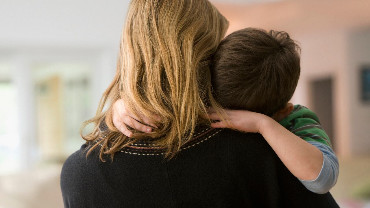 Foto de una madre con un menor de edad en sus brazos