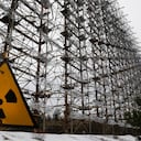 En esta imagen del 22 de noviembre de 2018, se ve un sistema de radar ultrasecreto de la era soviética que alguna vez fue utilizado como parte de la red de detección temprana de misiles de la Unión Soviética, detrás de un letrero de radioactividad, en Chernóbil, Ucrania. (AP Foto/Efrem Lukatsky, archivo)