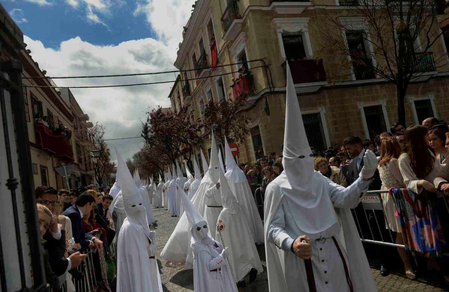 Penitentes del desfile de la hermandad 'La Paz' durante la procesión del Domingo de Ramos en Sevilla al inicio de la Semana Santa el 25 de marzo de 2018. Cristina Quicler / AFP