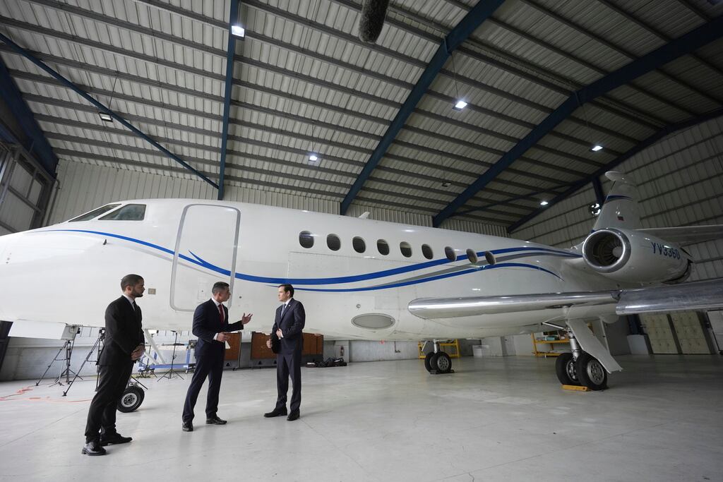 El Secretario de Estado de los Estados Unidos, Marco Rubio, a la derecha, escucha a Edwin F. López, agregado de Investigaciones de Seguridad Nacional del DHS, al centro, junto al avión del gobierno venezolano que Rubio anunció que estaba siendo incautado por los Estados Unidos durante una conferencia de prensa en el Aeropuerto Internacional La Isabela en Santo Domingo, República Dominicana, el jueves 6 de febrero de 2025. A la izquierda está el fiscal dominicano Enmanuel Ramírez. (Foto AP/Mark Schiefelbein, Piscina)