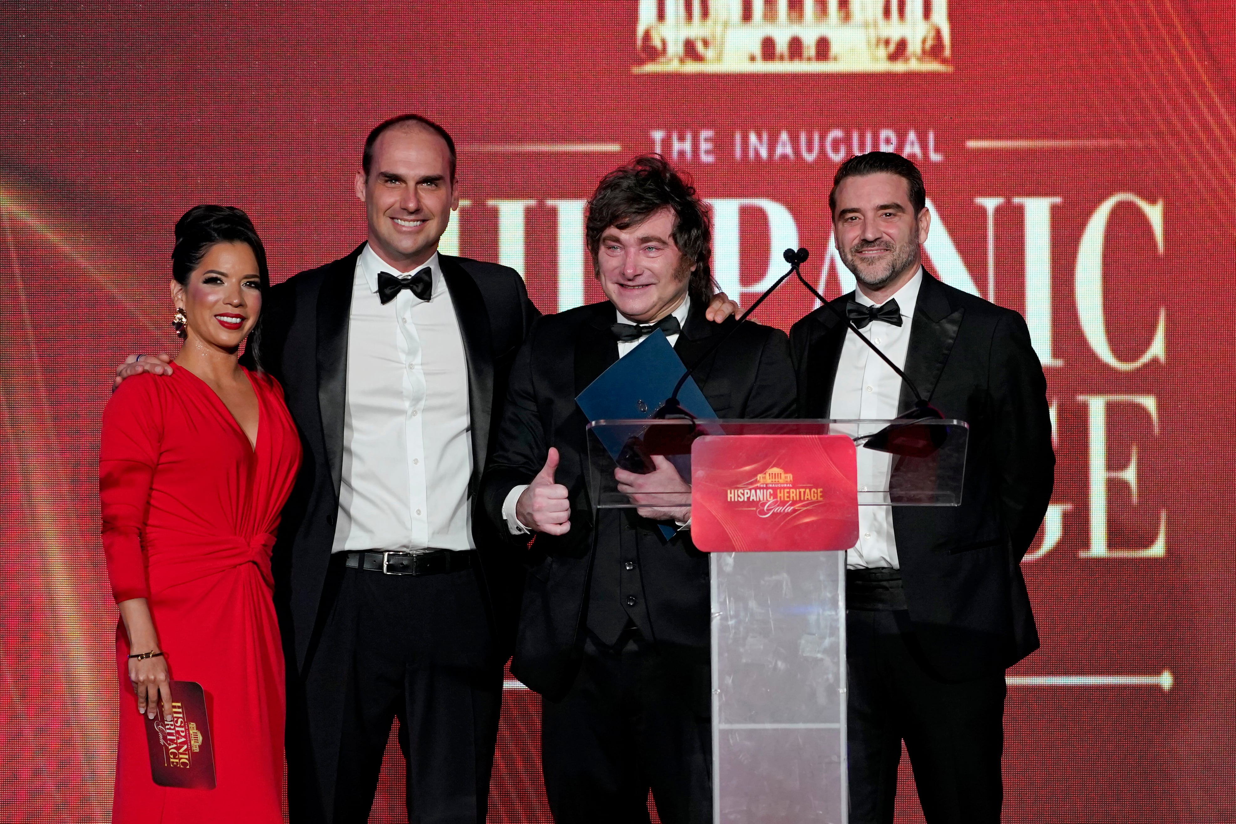 Gabriela Berrospi, Eduardo Bolsonaro, el presidente de Argentina, Javier Milei, y Javier Negre posan en el escenario durante la Gala de la Herencia Hispana en Washington D. C.