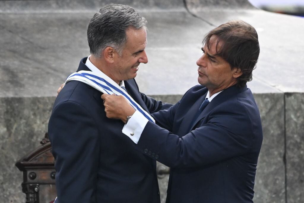 El presidente saliente de Uruguay, Luis Lacalle Pou, le pone la banda presidencial al presidente electo Yamandú Orsi en la Plaza Independencia en Montevideo, Uruguay.