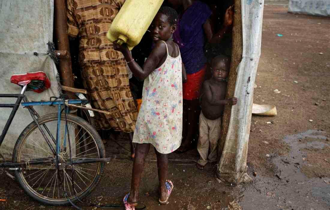 Los jóvenes refugiados sudaneses se refugian de una lluvia repentina en el centro de recepción de Imvepi (Foto de AP / Ben Curtis)  