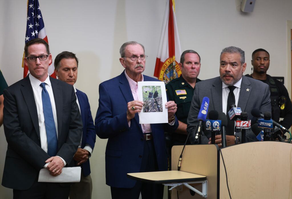 El sheriff del condado de Palm Beach, Ric Bradshaw (C), sostiene una fotografía del rifle y otros elementos encontrados cerca de donde se descubrió al sospechoso,en un presunto intento de asesinato contra Donald Trump.