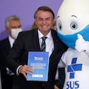 ARCHIVO - En esta fotografía de archivo del 16 de diciembre de 2020, el presidente brasileño Jair Bolsonaro posa para los fotógrafos con Zé Gotinha, la mascota de la campaña de vacunación del país, durante una ceremonia para presentar el Plan Nacional de Vacunación contra el COVID-19, en el palacio presidencial Planalto en Brasilia, Brasil. (AP Foto/Eraldo Peres, archivo)
