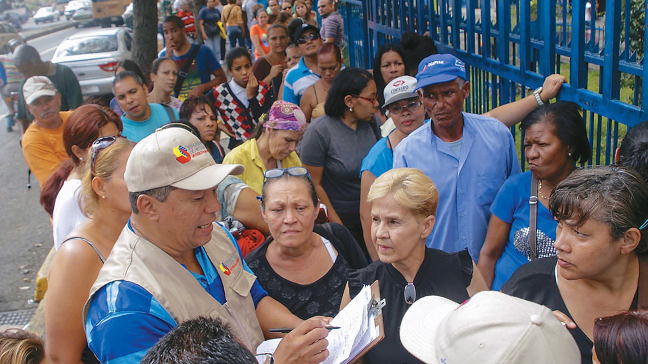 Las largas filas para conseguir productos esenciales se han convertido en parte de la vida cotidiana. El gobierno dice que se trata de una “guerra económica”, y los opositores se enfurecen.