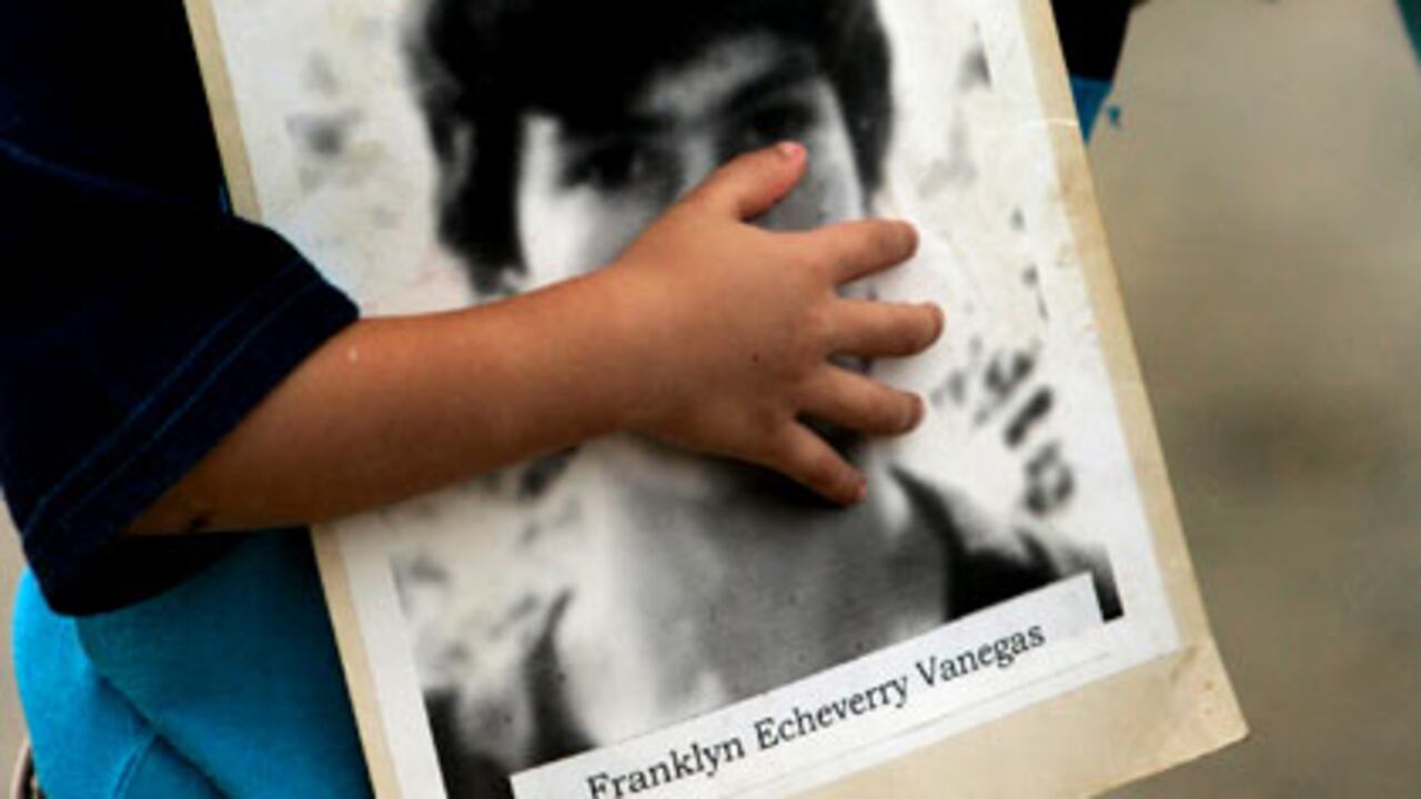 La mano de un niño sostiene la foto de Franklyn Echeverry Vanegas, una de las 342 personas de Trujillo que fueron asesinados en la década del 90. (Foto: AP)