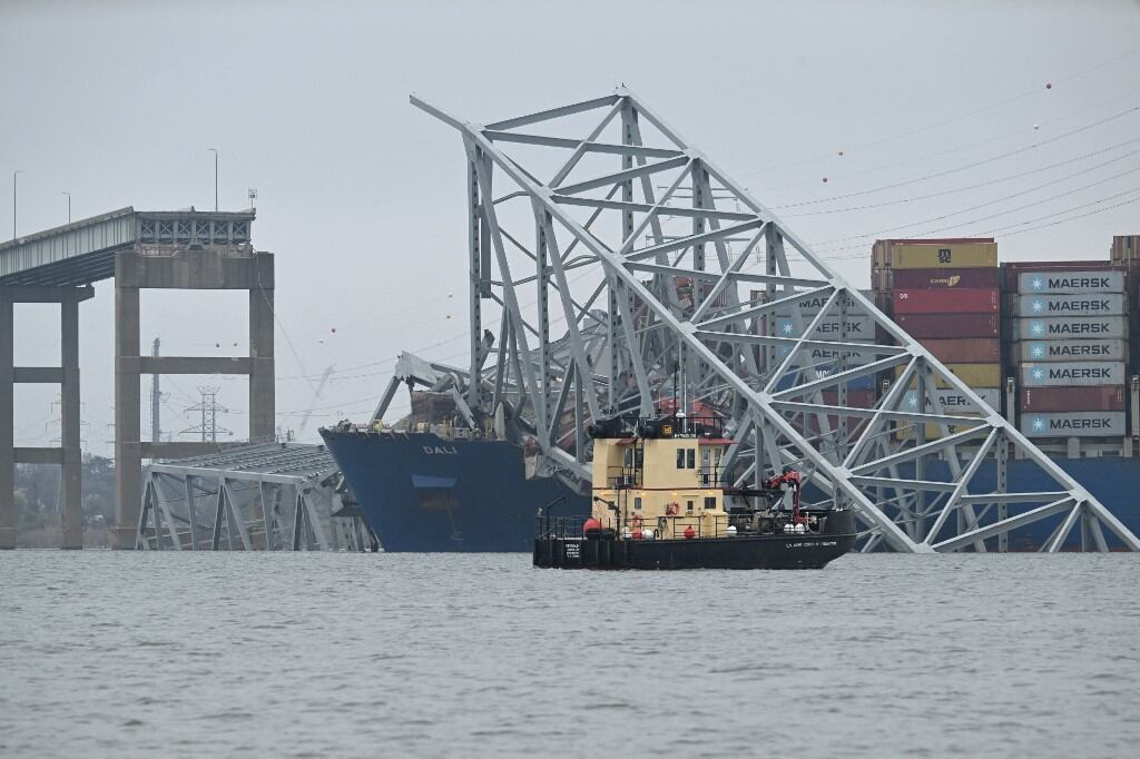 Un barco del Cuerpo de Ingenieros del Ejército de EE. UU. patrulla cerca del puente Francis Scott Key derrumbado después de que fuera golpeado por el buque portacontenedores Dali en Baltimore, Maryland, el 27 de marzo de 2024 (Foto de Jim WATSON / AFP)