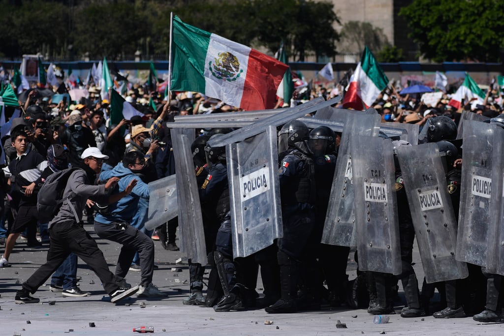Manifestantes cargan contra la policía durante una marcha juvenil antigubernamental en la Ciudad de México.