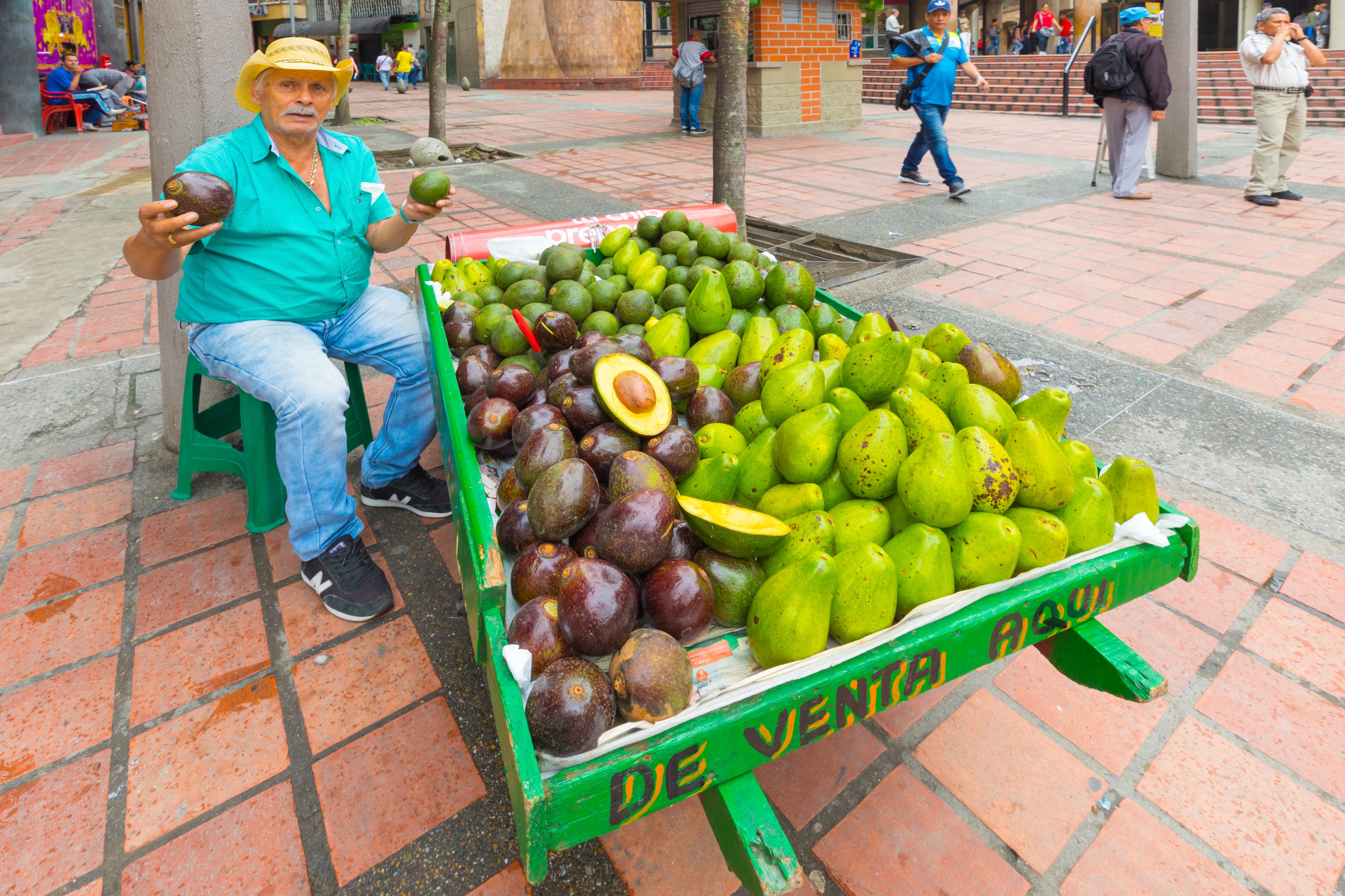 Medellin January 2018 In the morning, an old man sells fresh tropical fruit on his wagon in a street in the center of Medellin because people love to buy fruit in the street.