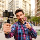 Streamer man records a video with a camera in a city