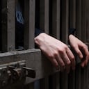 Woman hands on cage bars