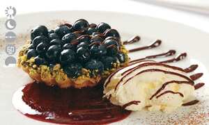 Tartaleta de arándanos rellena de mousse de chocolate blanco.