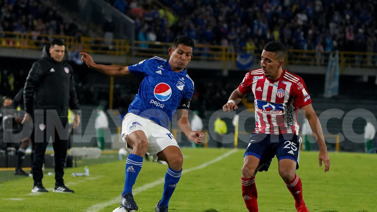 Macalister Silva (Millonarios) conduce el balón bajo la presión de Carlos Andrés Esparragoza (Junior)