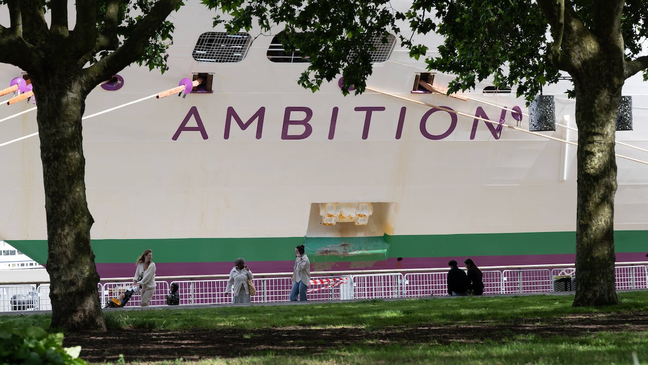 La gente pasa junto al crucero británico Ambition mientras las autoridades francesas ordenaron a 1.700 pasajeros y tripulantes permanecer a bordo debido a un brote de enfermedad gastrointestinal, en Burdeos, suroeste de Francia, el miércoles 13 de mayo de 2026