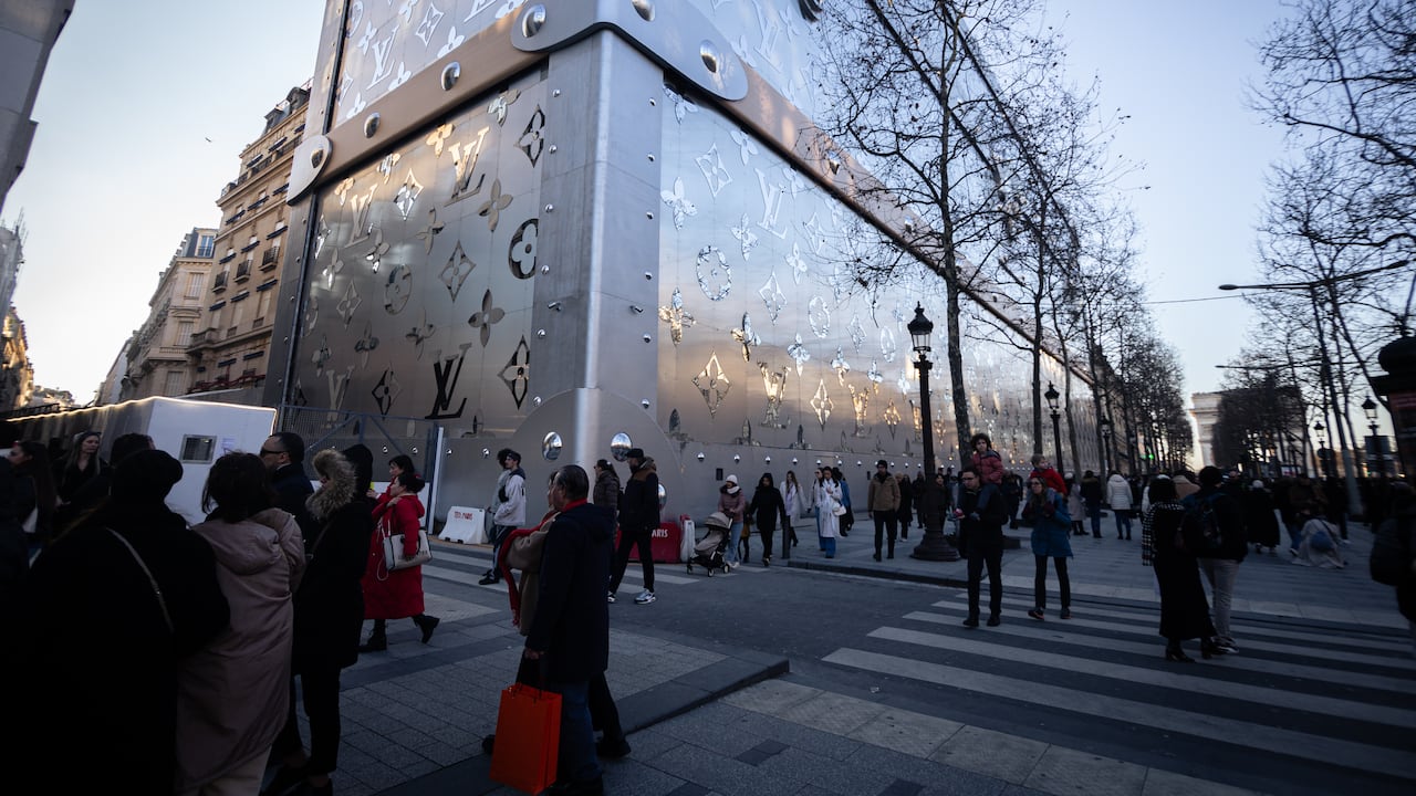 La gente pasa frente a la fachada temporal en forma de maleta de Louis Vuitton, que oculta las obras de construcción del nuevo hotel de lujo de la marca, que abrirá sus puertas en 2026, en la avenida de los Campos Elíseos de París, Francia, el 2 de febrero de 2025.