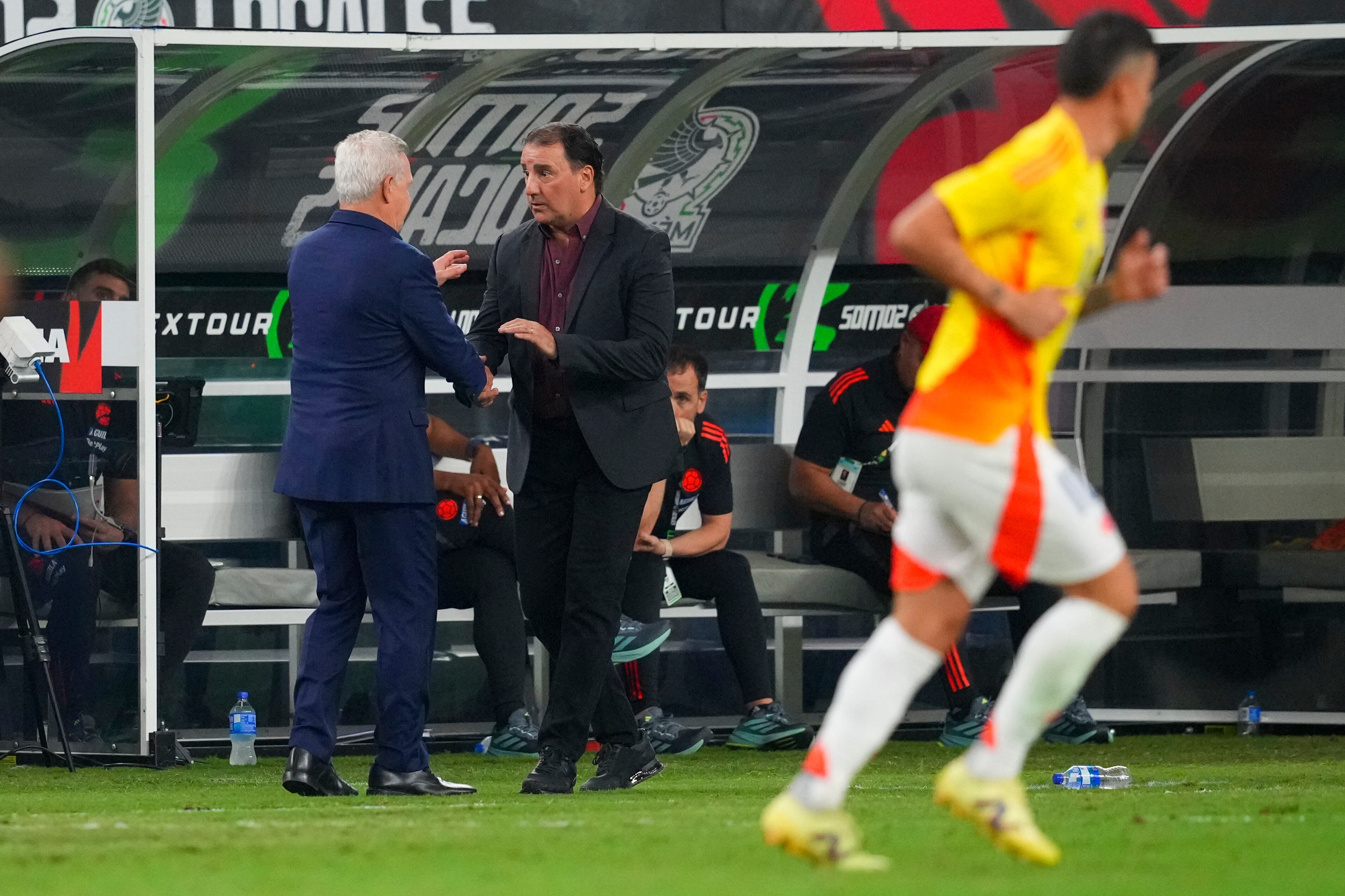 Mexico's head coach Javier Aguirre, left, talks with Colombia's head coach Nestor Lorenzo during the second half of an international soccer friendly match Saturday, Oct. 11, 2025, in Arlington, Texas. (AP Photo/Julio Cortez)