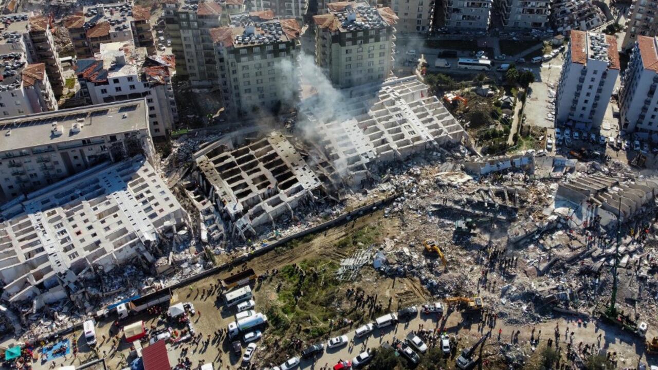 Esta vista aérea muestra edificios derrumbados en Hatay, sureste de Turquía, el 8 de febrero de 2023, dos días después de que un fuerte terremoto azotara la región. - Los equipos de búsqueda seguían sacando sobrevivientes el 8 de febrero de los escombros del terremoto que mató a más de 11.200 personas en Turquía y Siria, incluso cuando se reducía la ventana para los rescates. Durante dos días y noches desde el terremoto de magnitud 7,8, miles de buscadores han trabajado en temperaturas bajo cero para encontrar a los que siguen con vida debajo de los edificios derrumbados a ambos lados de la frontera. (Foto de DHA (Agencia de noticias Demiroren) / AFP) /