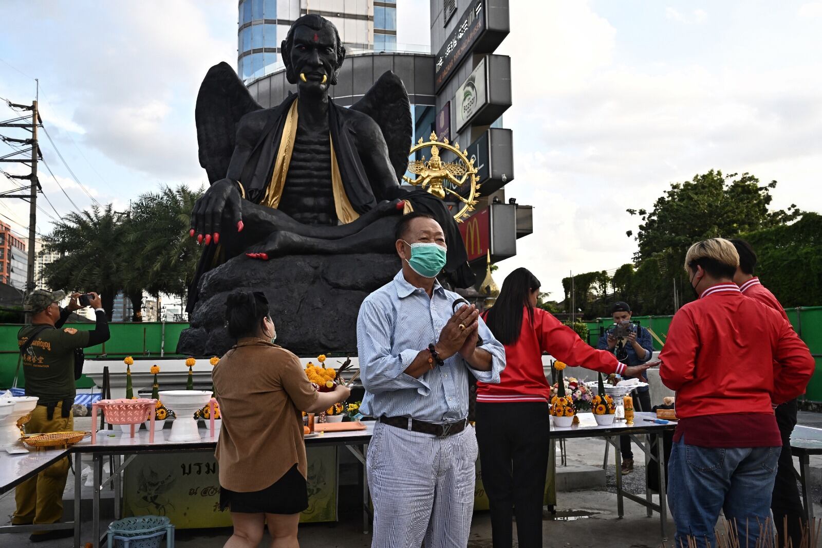 Una enorme estatua negra de una figura alada demacrada con colmillos dorados y garras escarlatas brillan en una concurrida calle de Bangkok, su repentina aparición activa la alarma y pide su eliminación.
Lillian SUWANRUMPHA / AFP
