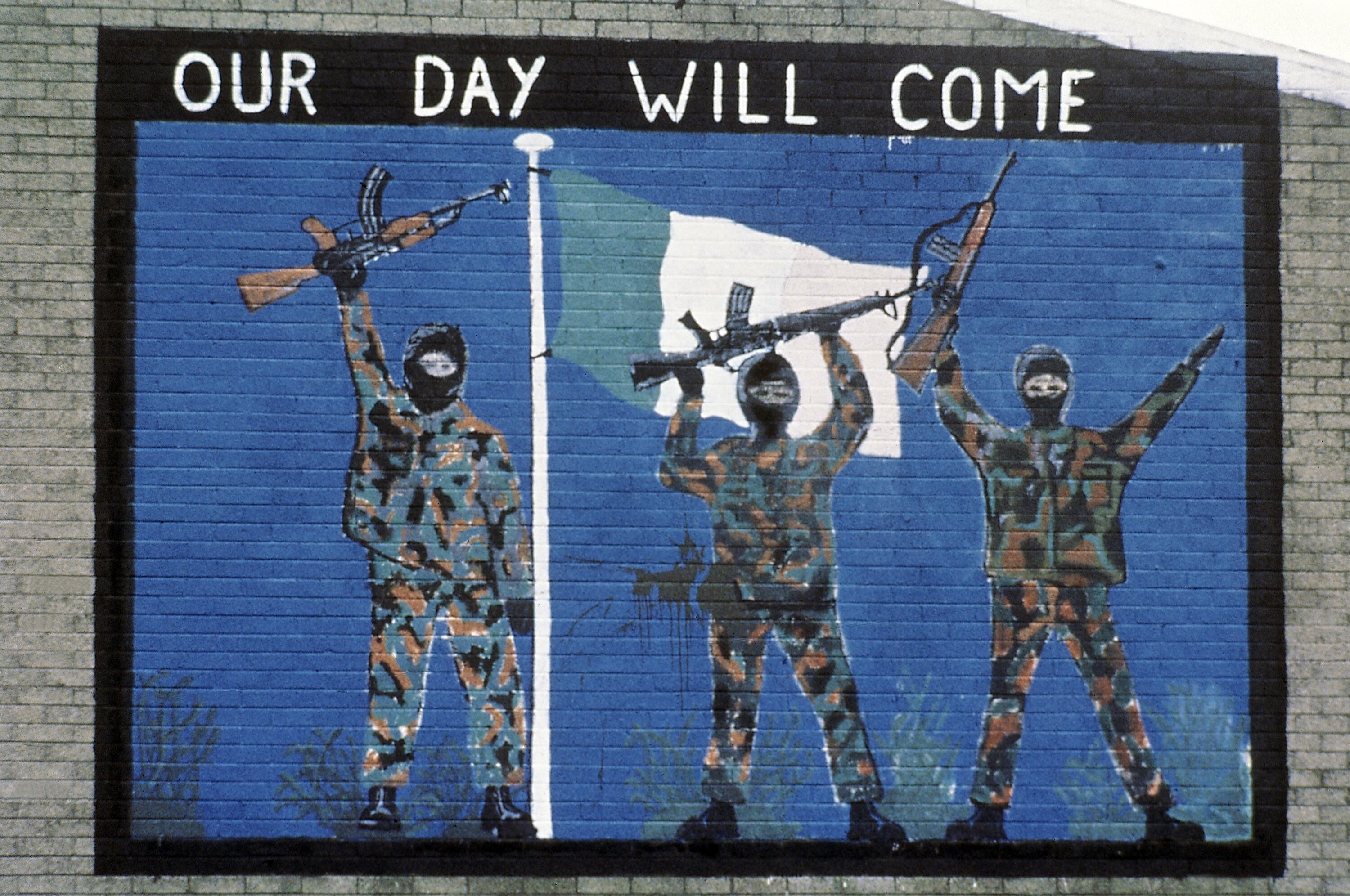 ARCHIVO - Una pintura mural que apoya al Ejército Republicano Irlandés, vista en el área católica de Belfast, Irlanda del Norte, en noviembre de 1985. Una investigación de siete años sobre las actividades de un ex agente doble del Ejército Republicano Irlandés concluyó el viernes que el espía probablemente fue el responsable. más muertes que vidas salvadas durante el conflicto de tres décadas en Irlanda del Norte. La investigación, conocida como Operación Kenova, investigó las acciones de "Stakeknife", un alto miembro del IRA que estaba pasando información a la inteligencia británica durante "los Problemas". (Foto AP/Peter Kemp, archivo)